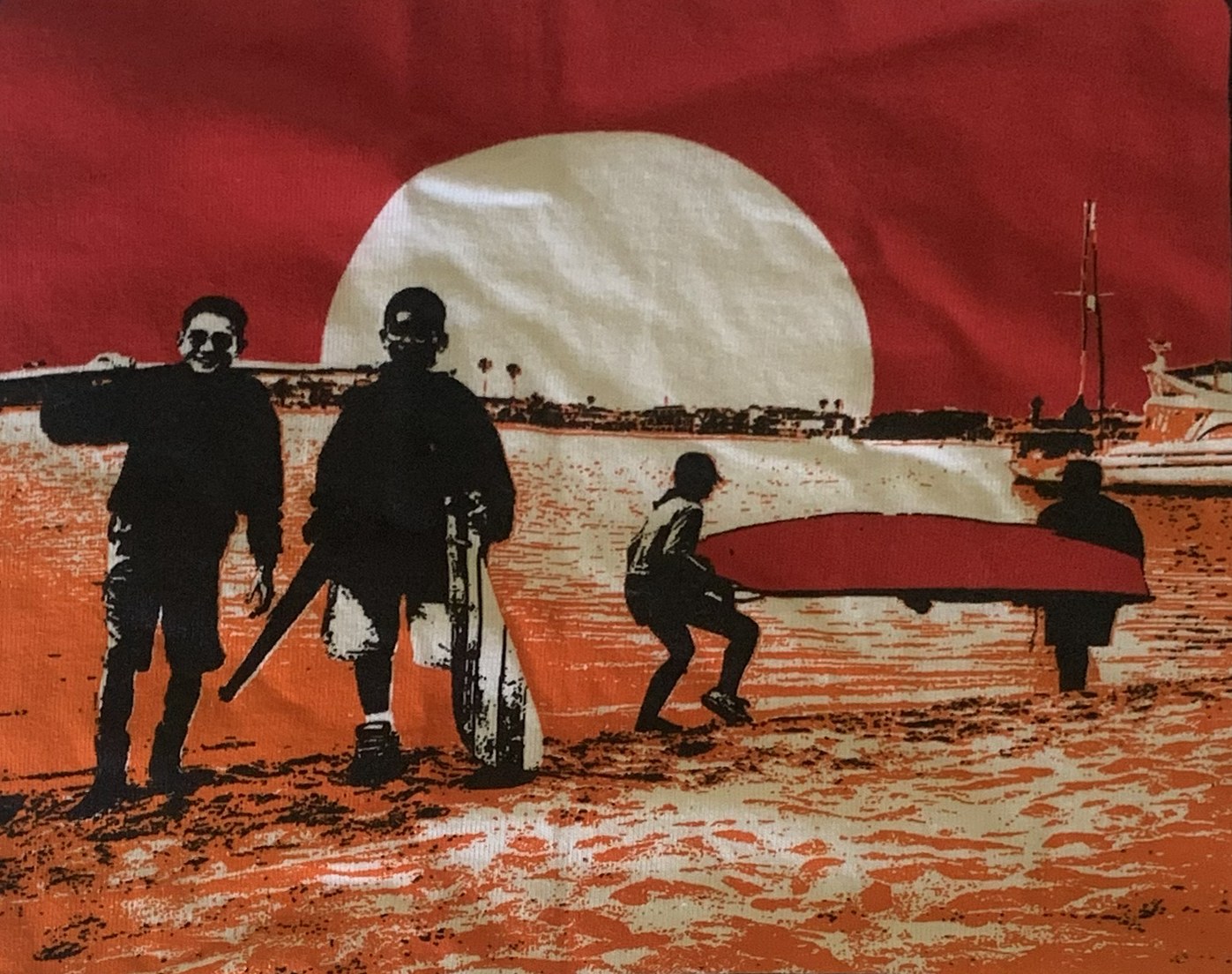 Junior sailors carrying a Sabot dinghy across the beach at sunset at Mission Bay Yacht Club.